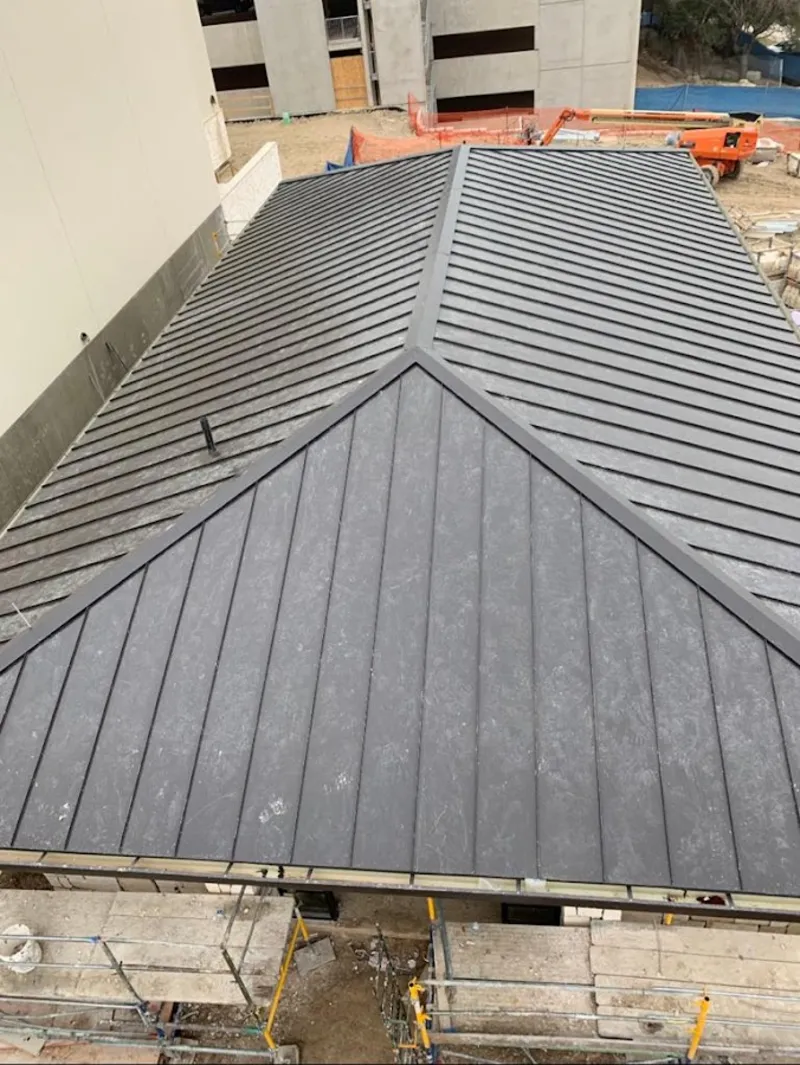 Commercial metal roof construction with crane equipment in Ewing